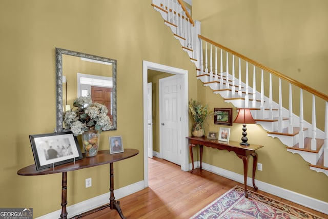 foyer featuring hardwood / wood-style floors and a towering ceiling