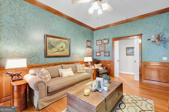 living room featuring crown molding, ceiling fan, and light hardwood / wood-style floors