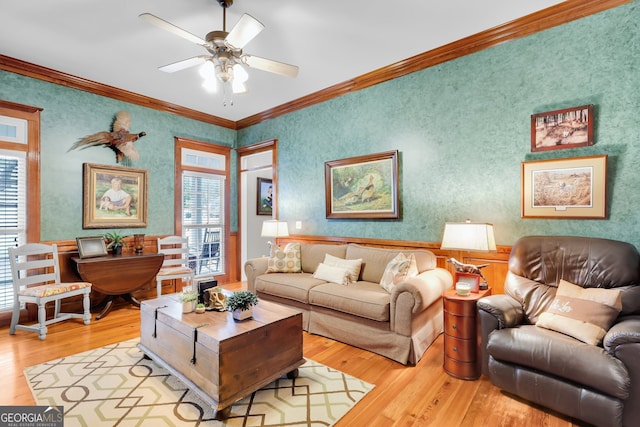 living room with light wood-type flooring, plenty of natural light, and ornamental molding