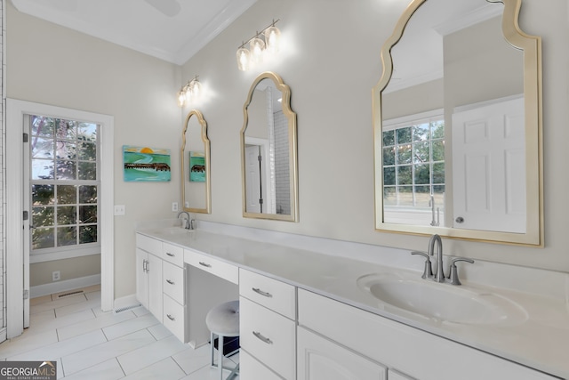 bathroom with tile patterned floors, crown molding, vanity, and a healthy amount of sunlight