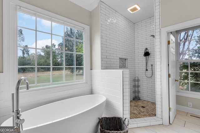 bathroom with tile patterned floors, separate shower and tub, and a healthy amount of sunlight