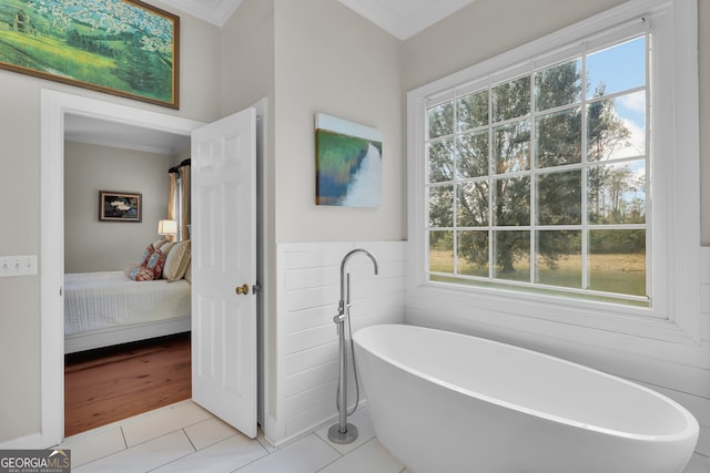 bathroom featuring a tub to relax in, crown molding, and tile patterned flooring