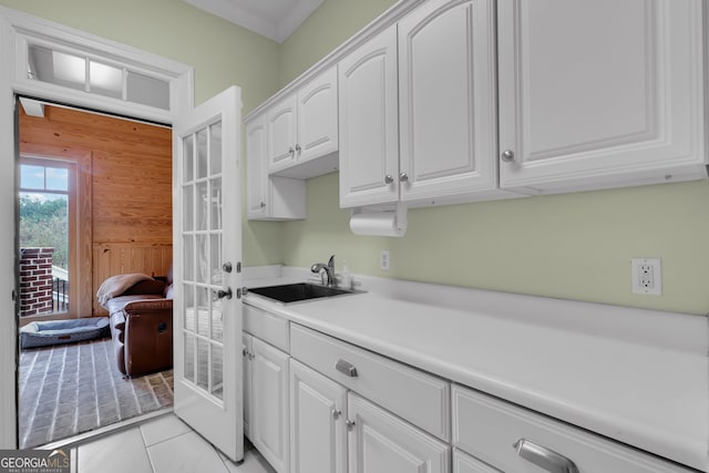 laundry area featuring sink and light tile patterned floors