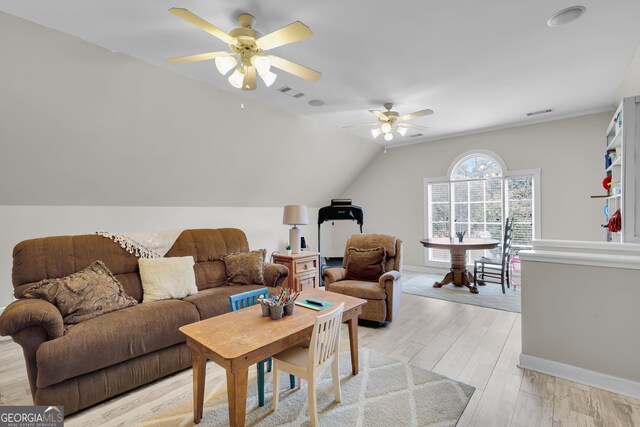 living room featuring ceiling fan, light wood-type flooring, and vaulted ceiling