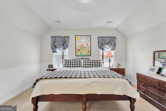 bedroom with carpet flooring, vaulted ceiling, and multiple windows