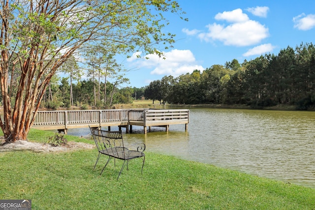 dock area with a lawn and a water view