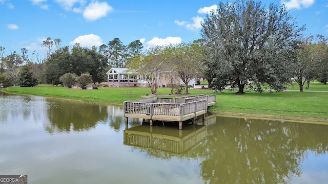 view of dock with a water view and a yard