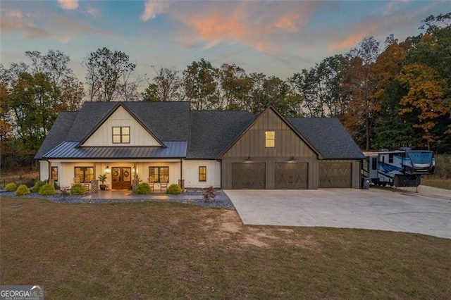 modern farmhouse style home featuring a yard and a garage