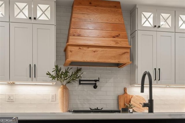 kitchen with tasteful backsplash and white cabinets