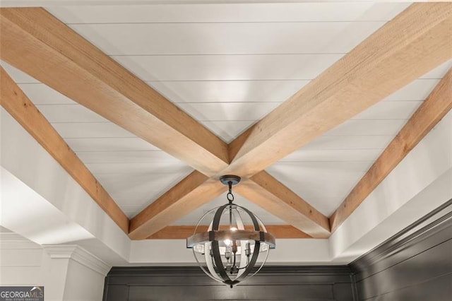 details featuring beam ceiling and a chandelier