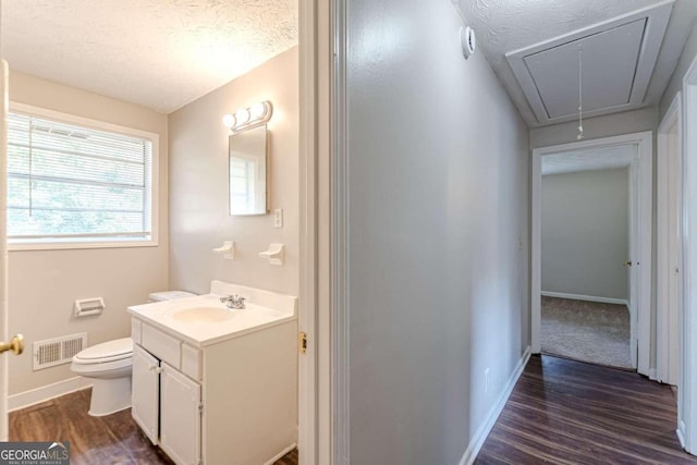 bathroom featuring vanity, a textured ceiling, wood-type flooring, and toilet