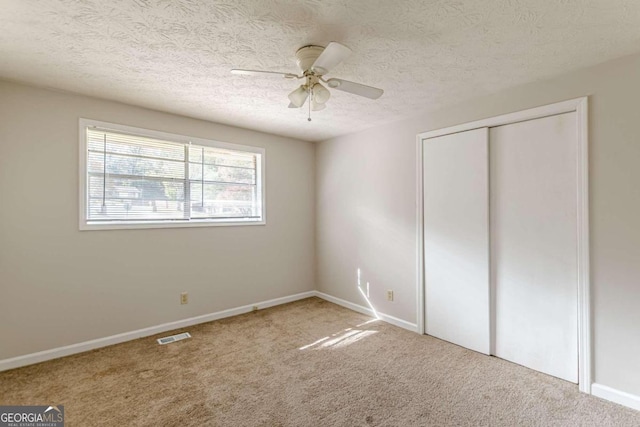 6275 S Skyline Dr, Douglasville, GA 30135 - unfurnished bedroom featuring carpet, a closet, a textured ceiling, and visible vents