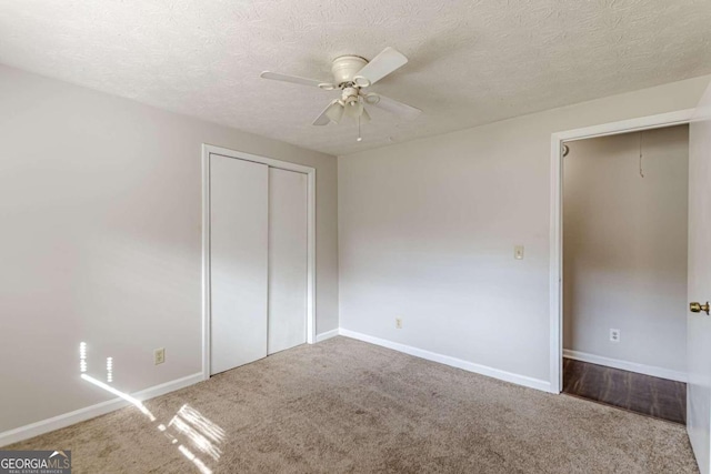 unfurnished bedroom featuring a textured ceiling, carpet flooring, a closet, and ceiling fan