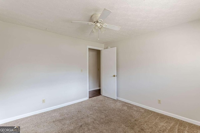 carpeted spare room featuring a textured ceiling and ceiling fan