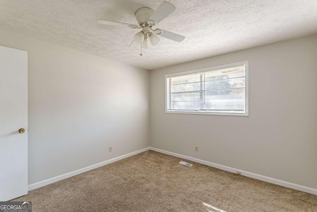 spare room with ceiling fan, carpet flooring, and a textured ceiling