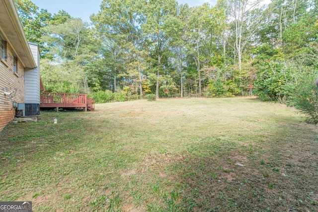 view of yard featuring a deck and central air condition unit