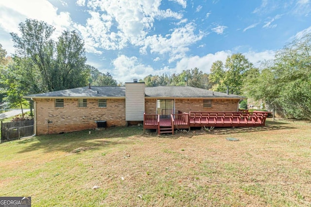 back of house featuring a wooden deck and a lawn