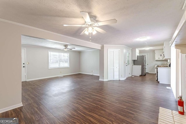 unfurnished living room featuring ornamental molding, ceiling fan, a textured ceiling, and dark hardwood / wood-style flooring