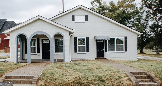 bungalow featuring a front lawn and covered porch