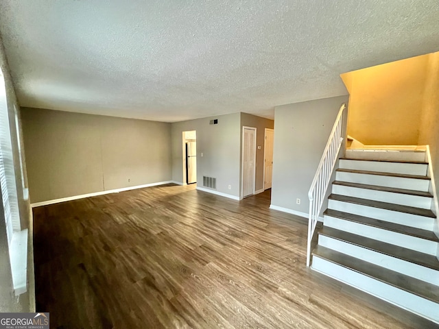 interior space with a textured ceiling and wood-type flooring