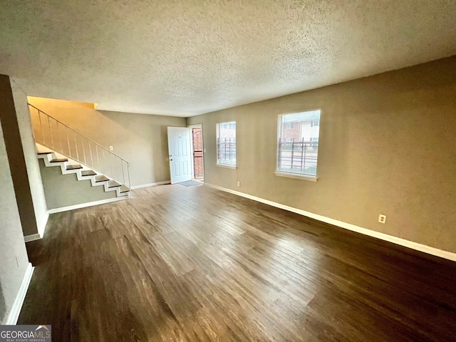 unfurnished living room featuring hardwood / wood-style floors and a textured ceiling