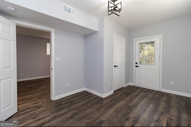 entryway with a notable chandelier and dark hardwood / wood-style floors