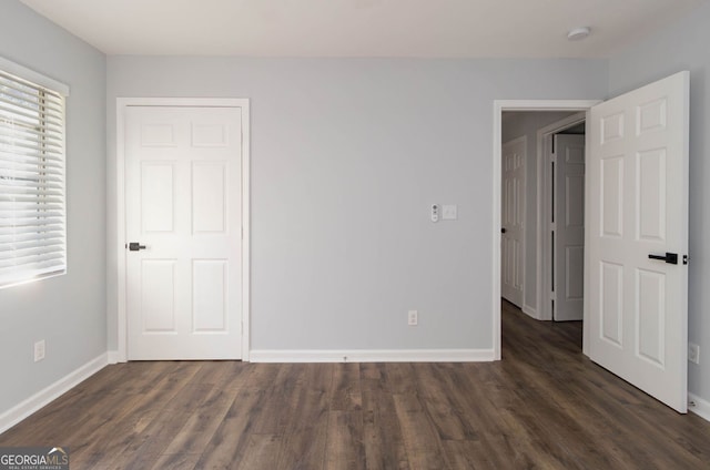 unfurnished bedroom featuring dark hardwood / wood-style floors