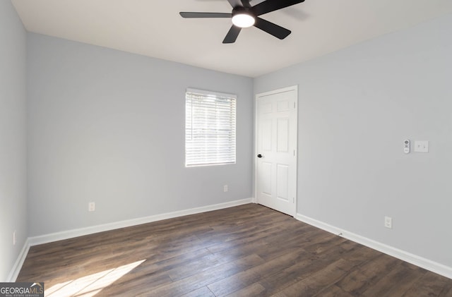 unfurnished room with ceiling fan and dark hardwood / wood-style flooring