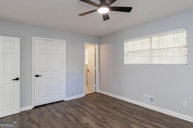 unfurnished bedroom with ceiling fan and dark hardwood / wood-style flooring