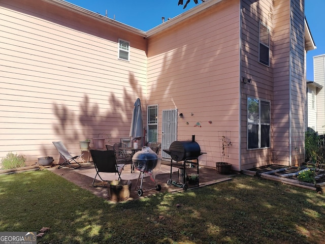 rear view of house with a patio and a lawn