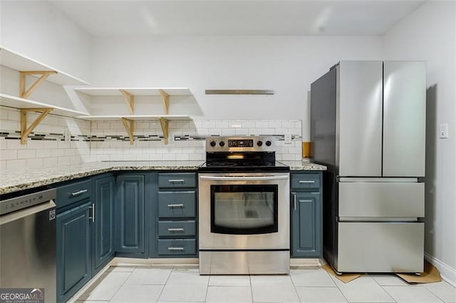 kitchen with backsplash, light tile patterned flooring, blue cabinets, appliances with stainless steel finishes, and light stone counters