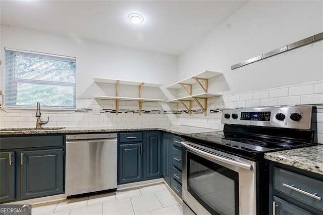 kitchen featuring sink, appliances with stainless steel finishes, light stone counters, and tasteful backsplash