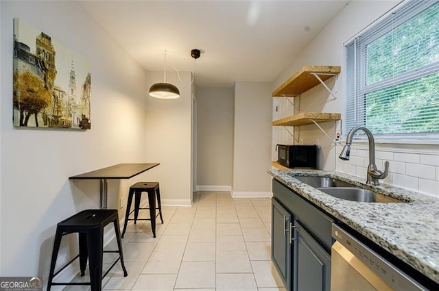 kitchen featuring dishwasher, backsplash, sink, light stone countertops, and light tile patterned flooring