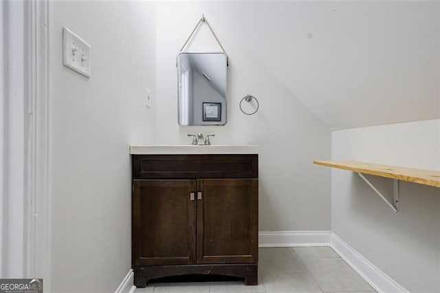 bathroom featuring vanity, vaulted ceiling, and tile patterned flooring