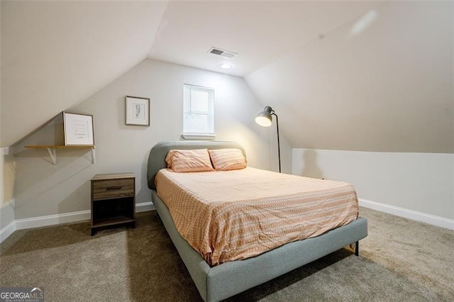 bedroom with vaulted ceiling and dark colored carpet