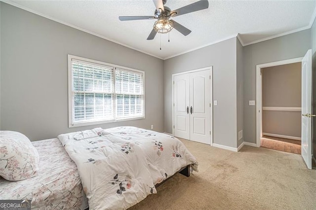 bedroom with ceiling fan, crown molding, light colored carpet, a textured ceiling, and a closet