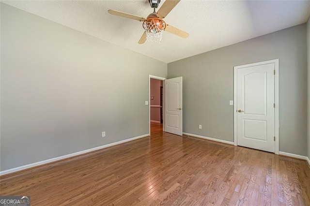 unfurnished bedroom featuring ceiling fan, light wood-type flooring, and a textured ceiling