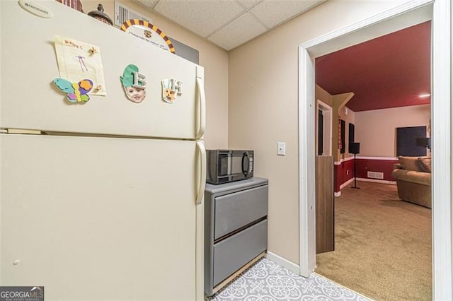 kitchen with light carpet, a drop ceiling, and white refrigerator