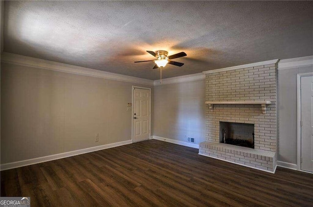 unfurnished living room with ceiling fan, a textured ceiling, ornamental molding, dark hardwood / wood-style floors, and a fireplace