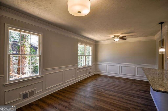 unfurnished dining area with dark wood-type flooring, ornamental molding, and plenty of natural light