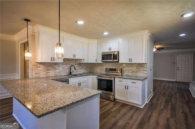 kitchen featuring appliances with stainless steel finishes, white cabinetry, and pendant lighting