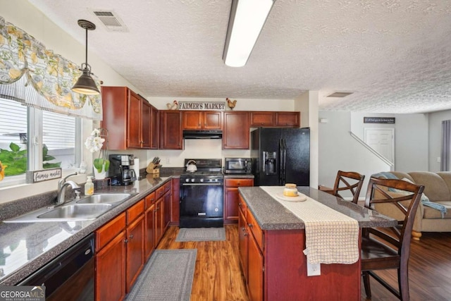 kitchen featuring black appliances, sink, a textured ceiling, pendant lighting, and dark wood-type flooring