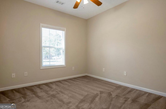 carpeted spare room featuring ceiling fan