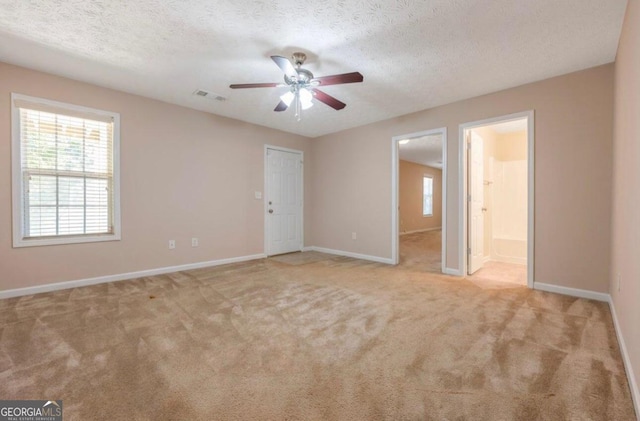 carpeted spare room featuring ceiling fan and a textured ceiling