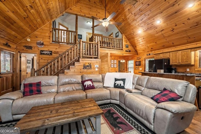 living room featuring wood ceiling, wooden walls, high vaulted ceiling, and light wood-type flooring