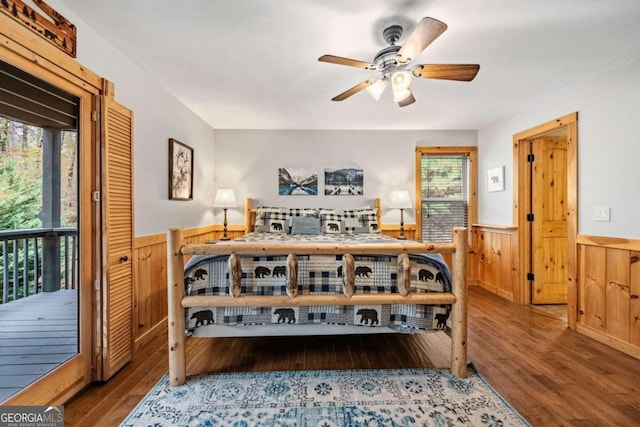 bedroom with multiple windows, hardwood / wood-style flooring, and access to outside