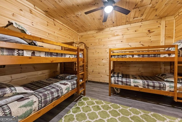 bedroom with dark hardwood / wood-style flooring, wooden walls, and wooden ceiling