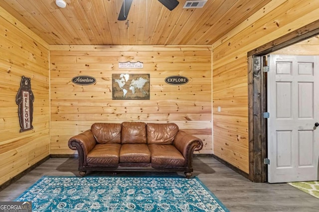 sitting room featuring dark hardwood / wood-style flooring, wooden ceiling, ceiling fan, and wood walls