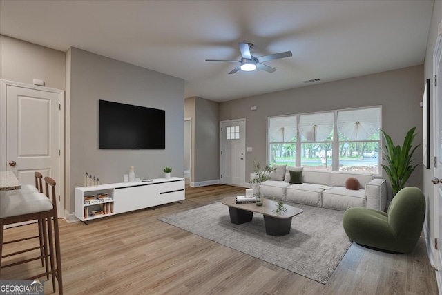 living room featuring light wood-type flooring and ceiling fan