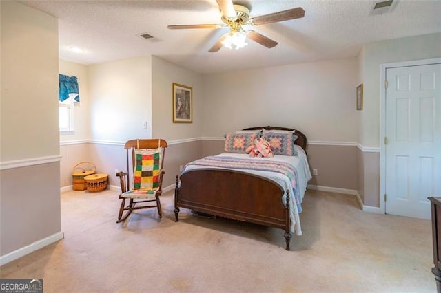 bedroom with a textured ceiling, light carpet, and ceiling fan